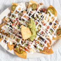 Frida'S Nachos · Fried tortilla chips covered with black beans and cheese sauce. Topped with pico de gallo, g...