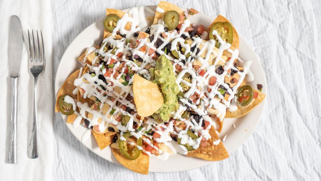 Frida'S Nachos · Fried tortilla chips covered with black beans and cheese sauce. Topped with pico de gallo, guacamole, sour cream, and pickled jalapeños. Add meat for an additional charge.
