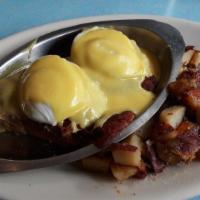 Eggs Benedict · Two dropped eggs, Canadian bacon, and grilled tomato on an english muffin topped with hollan...