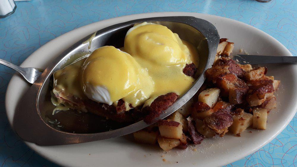 Eggs Benedict · Two dropped eggs, Canadian bacon, and grilled tomato on an english muffin topped with hollandaise sauce. Served with home fries.