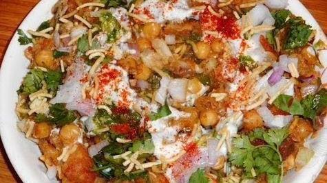 Samosa Chaat · Samosa chaat is a tangy, spicy, and crispy delicious Indian street food where samosa is mashed and topped with chick peas, tomatoes, onions, cilantro, yogurt, and tamarind and mint chutney.