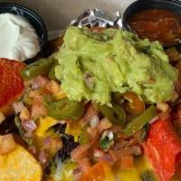 Buenos Nachos · Tri color tortilla chips topped with melted cheddar-jack, pico de gallo, jalapeños, sour cre...