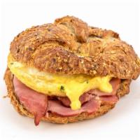 Eggs Benny Croissant · A freshly cracked egg, carved signature ham, and hollandaise sauce on a freshly baked multig...