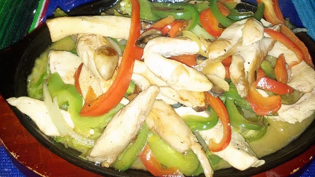 Fajitas De Pollo · Chicken fajitas served on a sizzling plate with red and green peppers, onions, mushrooms, rice, beans, guacamole and flour tortillas.