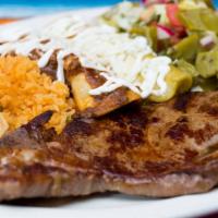 Carne A La Tampiquena Platter · Rib-eye with two enchiladas, mole, green sauce, cactus salad, rice and beans.