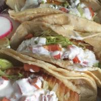 Beer Battered Fish Taco · Beer battered cod topped with red and green cabbage chipotle cream sauce with pica degallo o...
