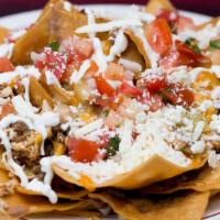 Nachos Mixtos · Ground beef and chicken nachos dipped in refried beans and topped with pico de gallo, lettuc...