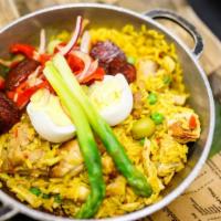 Arroz Con Pollo · Saffron long-grain rice, boneless chicken, green peas, Manzanilla olives, hard-boiled egg, a...
