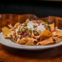 Traditional Nachos · Freshly fried corn tortilla chips topped with your choice of main ingredient, beans, sour cr...
