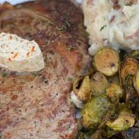 Grilled Ribeye · 12 oz Grilled Ribeye Topped with Garlic Butter. Served with Mashed Potatoes and Roasted Brus...