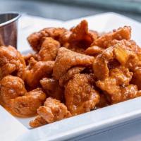 Chicken Bites · Lightly breaded and fried chicken tenderloin bites. Tossed in a house made honey hot sauce, ...