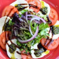 Caprese Salad · Fresh mozzarella, tomatoes, spring mix, thin sliced red onions, homemade pistachio pesto, an...