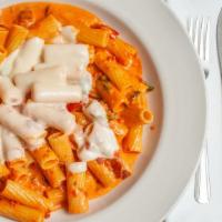 Vodka Rigatoni ￼ · Rigatoni pasta tossed in a pink cream sauce and prosciutto. Served with homemade bread and c...