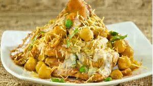 Samosa Chaat · Samosa topped with slow cooked chickpea curry, yogurt, mint & tamarind sauce.