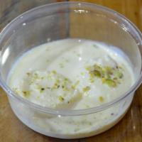 Rasmalai · Sweet milk patties, dipped in cardamom flavored milk with pistachio.