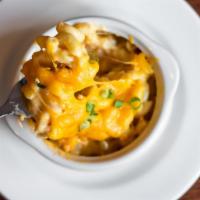 Baked Mac & Cheese · Traditional mac and cheese topped with smoked cheddar and scallions
