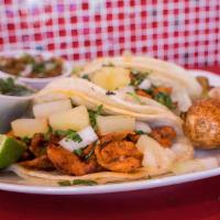 Al Pastor Taco · Pork marinated with a achiote sauce and spices and topped with onion and cilantro and pineap...