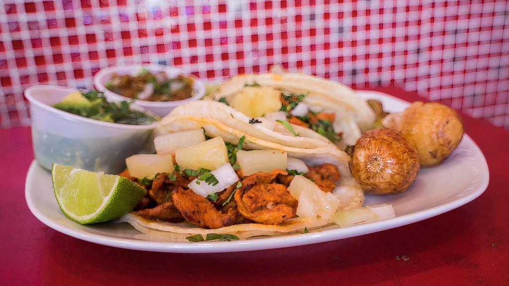 Al Pastor Taco · Pork marinated with a achiote sauce and spices and topped with onion and cilantro and pineapple.