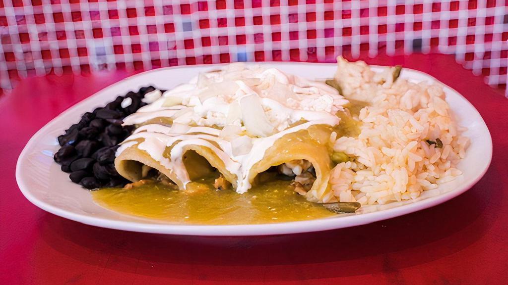 Green Enchiladas · Corn tortillas with chicken smothered in a green tomatillo sauce and topped with fresh Mexican cheese, onions, and crema (sour cream).