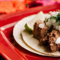 Lengua Taco · Beef tongue, garnished with cilantro and onions.