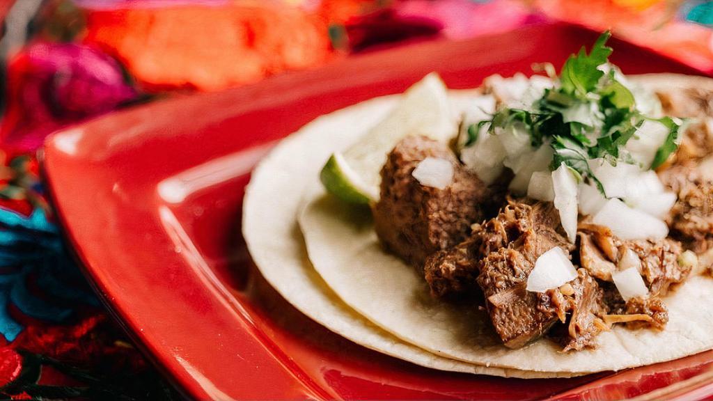 Lengua Taco · Beef tongue, garnished with cilantro and onions.