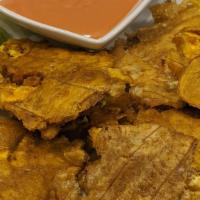 Tostones · Green deep fried plantains, served with a side of salsa rosada.