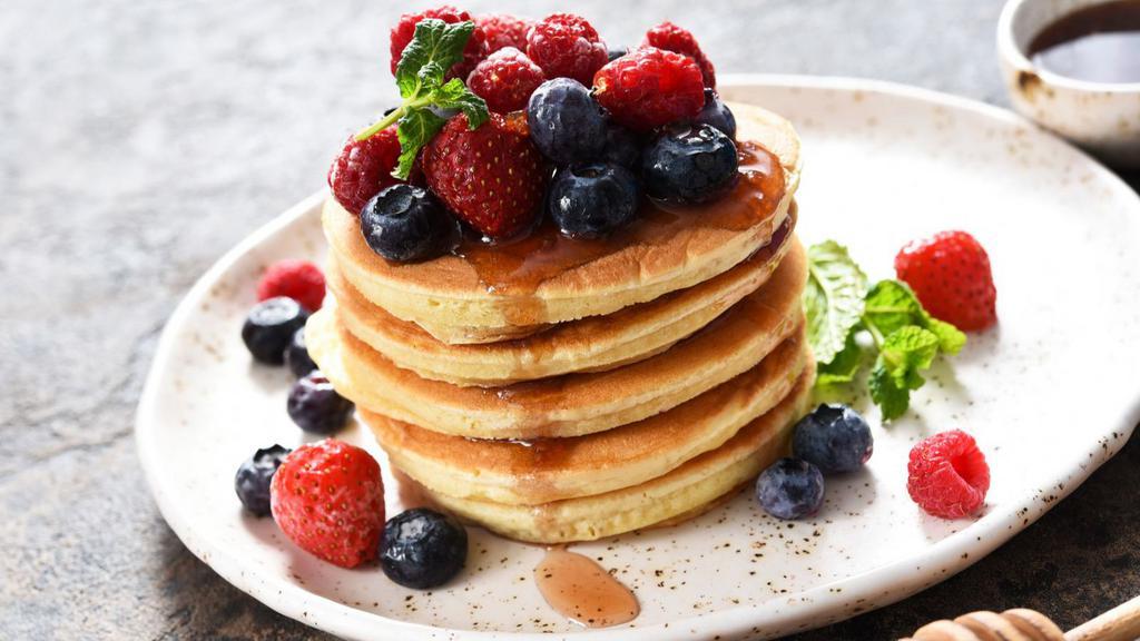 Mix Berry Pancakes · Plain airy pancakes with fresh blueberries and strawberries, served with butter, whipped cream and powdered sugar.