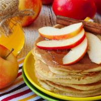 Apple Cinnamon Pancakes · Cinnamon flavored pancakes with finely chopped apples on top, served with butter, whipped cr...