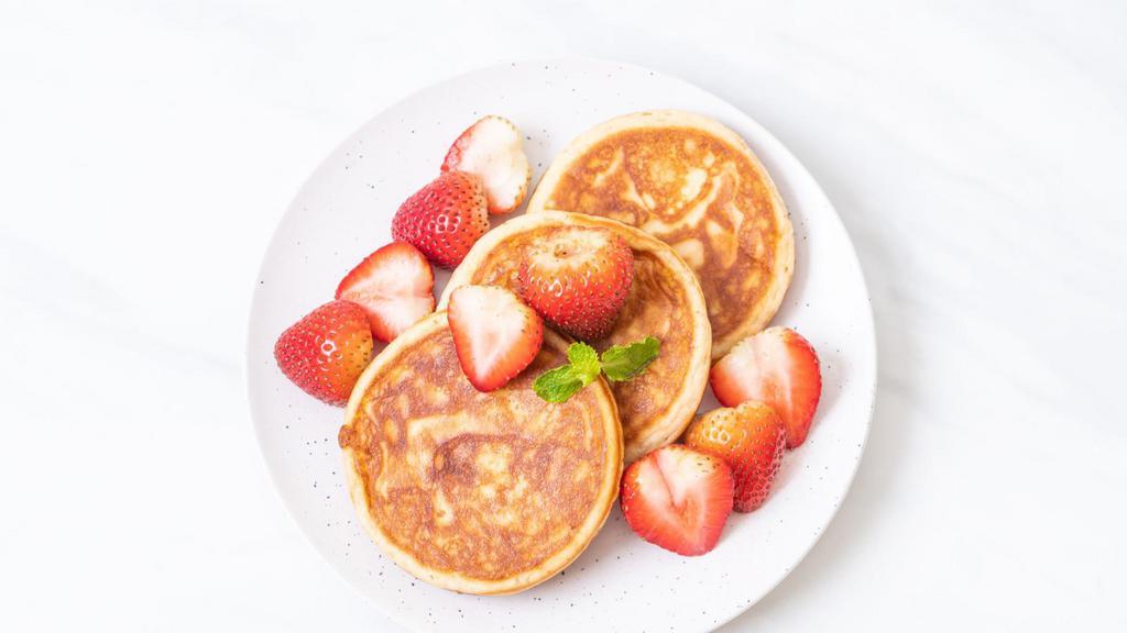 Strawberry Pancakes · Buttermilk pancakes topped with fresh strawberries, served with butter, whipped cream and powdered sugar.