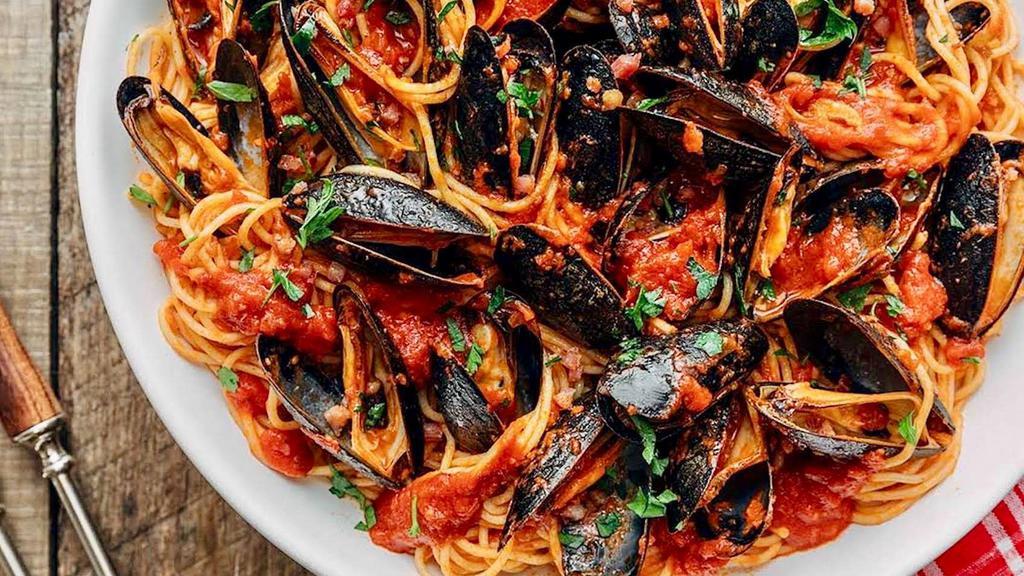 Linguine Alle Cozze · Fresh mussels in a spicy tomato sauce with garlic, olive oil & white wine.