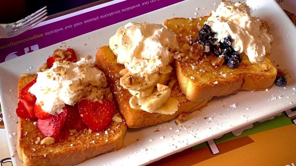 French Riviera · Three pieces of French toast overstuffed to the max with strawberries, bananas, blueberries, topped with whipped cream and nuts.