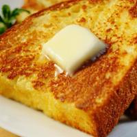 Savory French Toast · Three slices of thick, egg-washed challah bread with two fried eggs and Cheddar cheese, serv...
