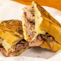 The Cubano · Authentic braised Cuban pork, ham, Swiss, pickles, mustard pressed on crusty sub.