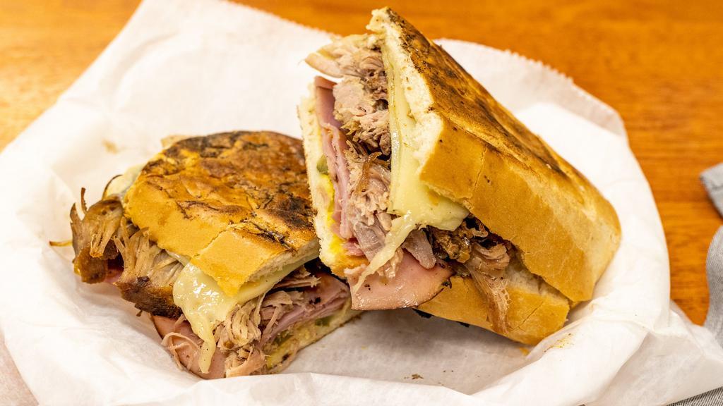 The Cubano · Authentic braised Cuban pork, ham, Swiss, pickles, mustard pressed on crusty sub.