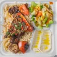 Lamb Shish Kabab Meal · Pieces of grilled marinated lamb, grilled tomato, and onion, served on a bed of rice pilaf, ...