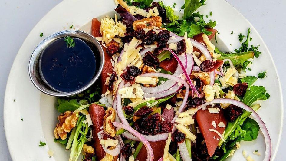 Poached Pear Salad · Red wine poached pears on field greens with craisins, red onions, walnuts, smoked Gouda and a balsamic vinaigrette.