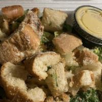 Caesar Salad · A bed of romaine lettuce topped with homemade garlic bread.