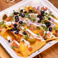 Nachos · Large portion of house fried corn tortilla chips topped with spicy queso cheese +  protein +...