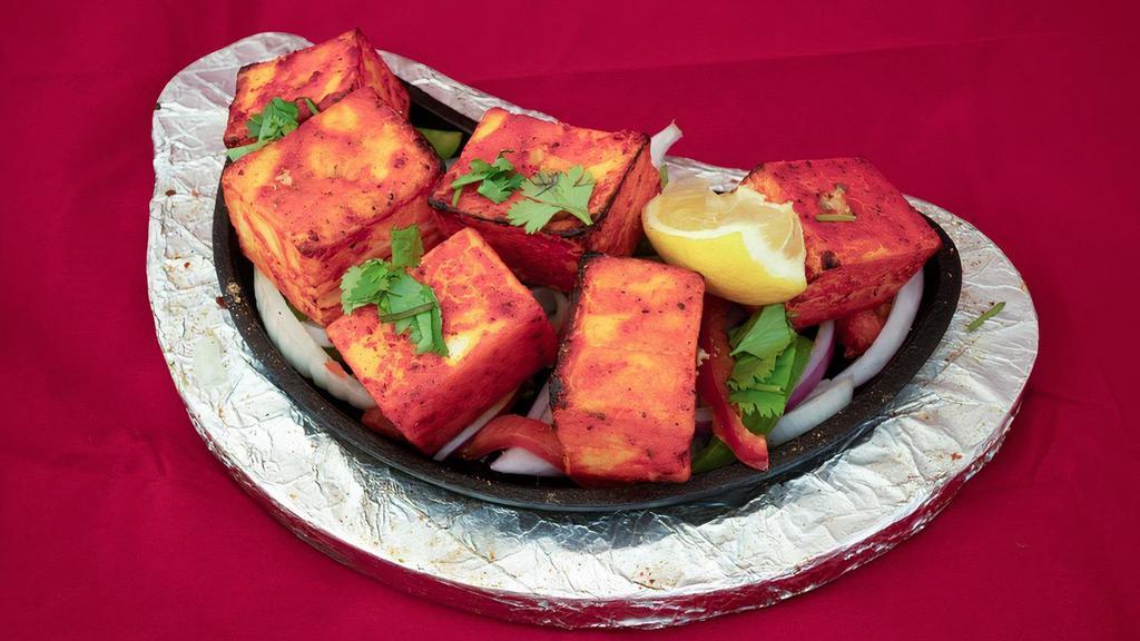 Anchaari Paneer Tikka · Home made paneer cheese marinated in our special Indian pickle sauce, grilled to perfection.