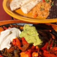 Trio Sizzling Fajita · Vegetarian and gluten-free. Chicken, steak, and shrimp. Topped with sour cream and guacamole...