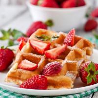 Strawberry Belgian Waffles · Crisp cake of batter baked a waffle iron topped with fresh strawberries, served with a side ...