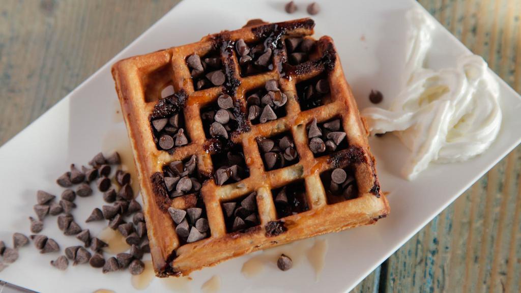 Chocolate Chip Belgian Waffles · Crisp cake of batter baked in a waffle iron topped with chocolate chips, served with a side of butter waffles and syrup.