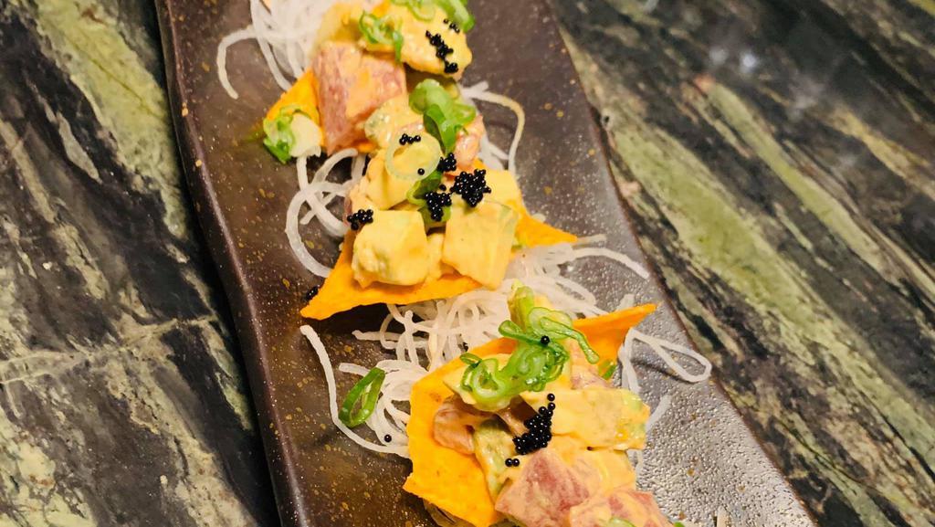 Poke Chips · Chopped wild tuna and avocado, topped with homemade spicy mayo, black caviar, scallions and sesame seeds and served with organic tortilla chips.