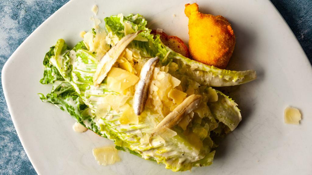 Caesar Salad · Whole leaves of baby Romaine tossed in a white truffle infused dressing. Served with white anchovies and a fried poached egg.