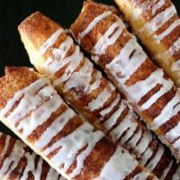 Cinnamon Sticks · Our signature dough covered in cinnamon and sugar baked to perfection and drizzled with icin...