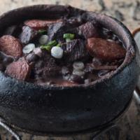 Feijoada Completa · Brazilian national dish. Black beans stew with fresh & dried meat, pork, sausage & bacon. Se...