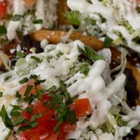 Tostadas · Three crispy tortillas topped with refried black beans, your choice of meat or vegetables, l...