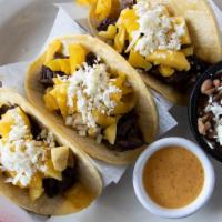 Mexico City Tacos · Charbroiled skirt steak, caramelized onions, and melted Jack cheese. Topped with Cotija chee...