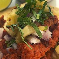 Al Pastor Taco. · Pork marinated in a combination of dried chilies, spices and pineapple and slowly cooked. To...