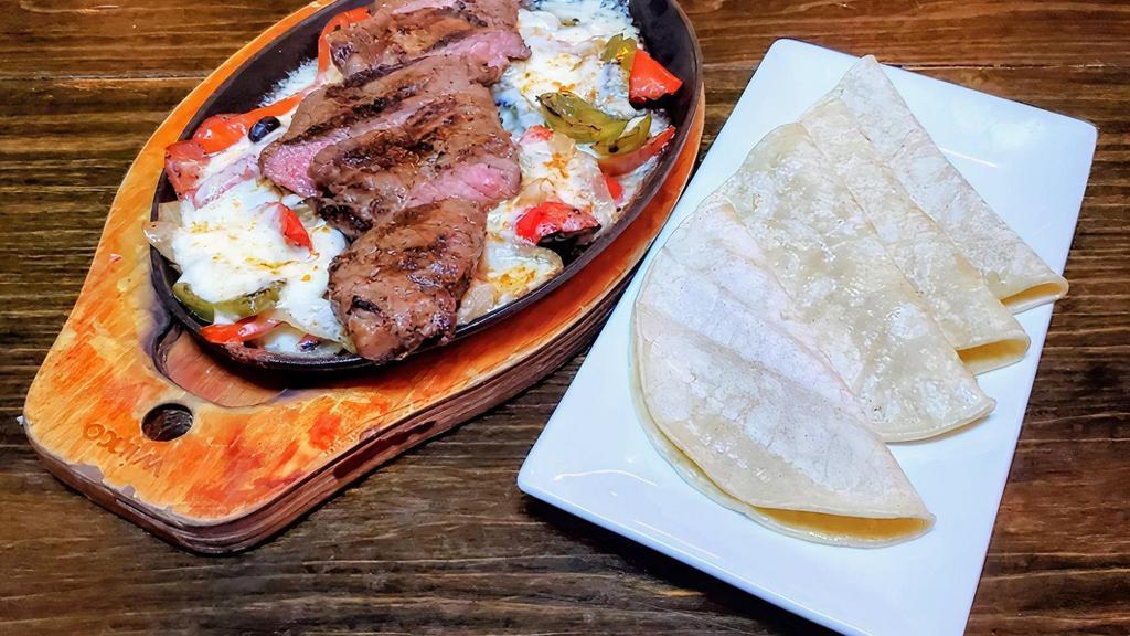 Steak Fajitas · Grilled onion, red & green peppers, Oaxaca cheese & corn tortillas. Served with white rice.